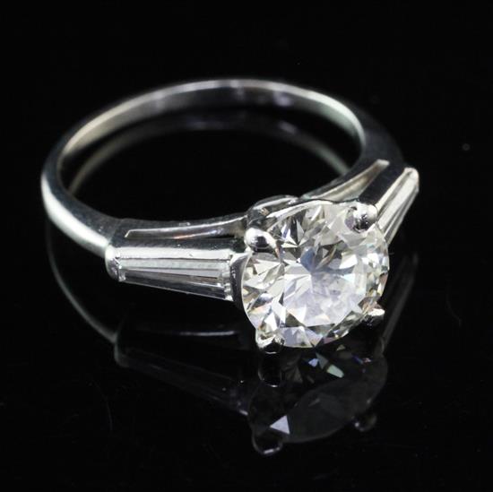 A platinum and single stone diamond ring with trapeze cut diamond set shoulders, size O.